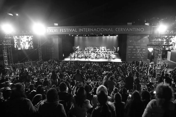 Explanada de la Alhóndiga de Granaditas, en Guanajuato, con escenario y público al atardecer durante un concierto.