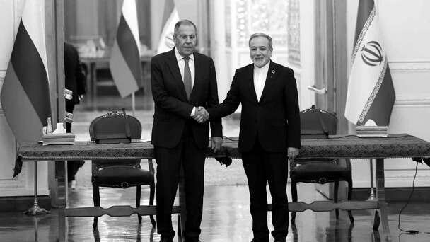 Dos cancilleres de pie ante banderas de Rusia e Irán durante una conferencia de prensa conjunta en Teherán.